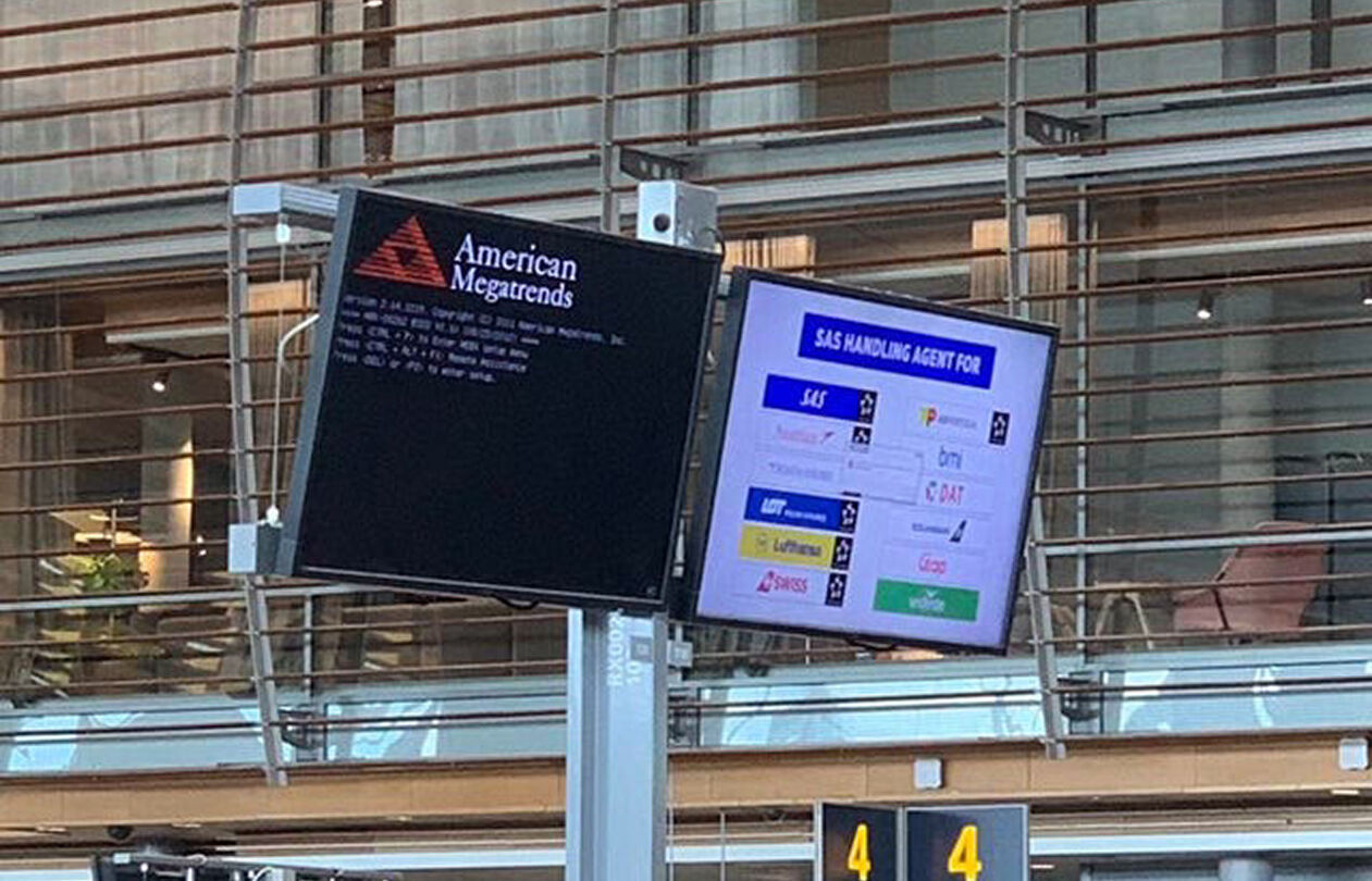 Two digital displays in an airport setting. One shows "American Megatrends" and the other lists SAS handling agents for various airlines.