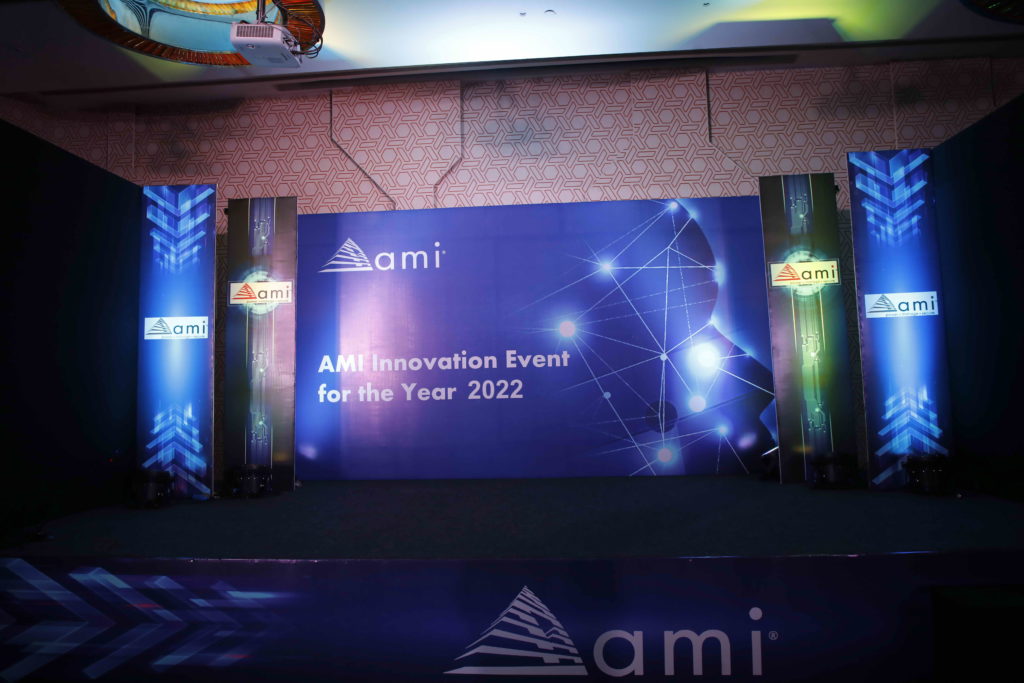 2022 年 AMI 创新活动的舞台布置，以蓝色背景衬托 AMI 标志和装饰灯光。